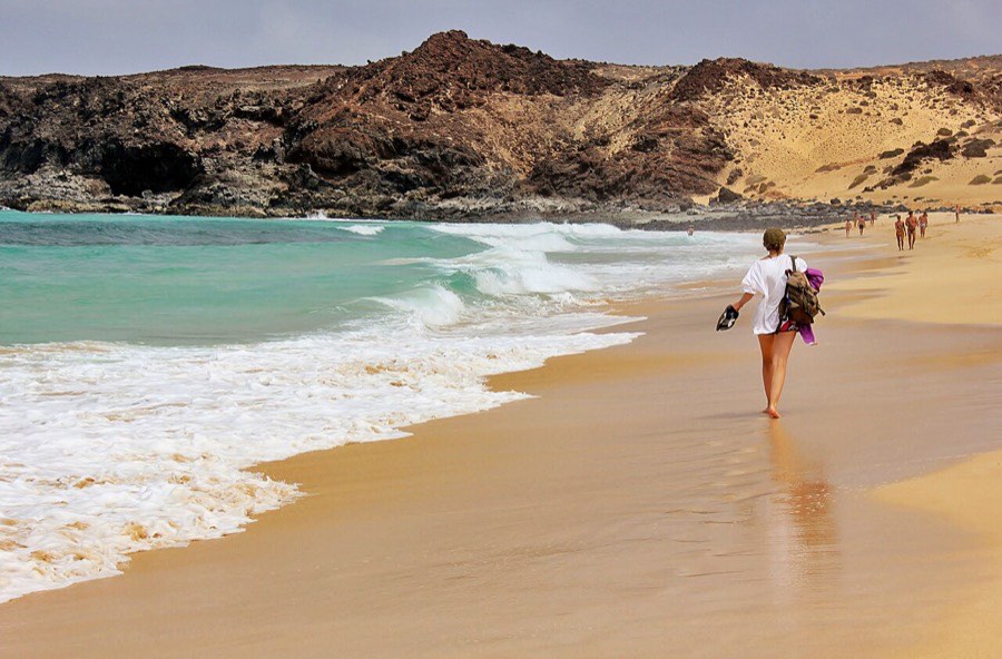 Playa de las Conchas, con oleaje y el acantilado volcánico al fondo